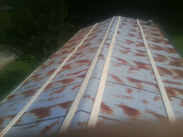 Rusted metal roof panels with new wood purlins before replacement — Storm Damage Roof Repair in Robins by Roofing Brothers