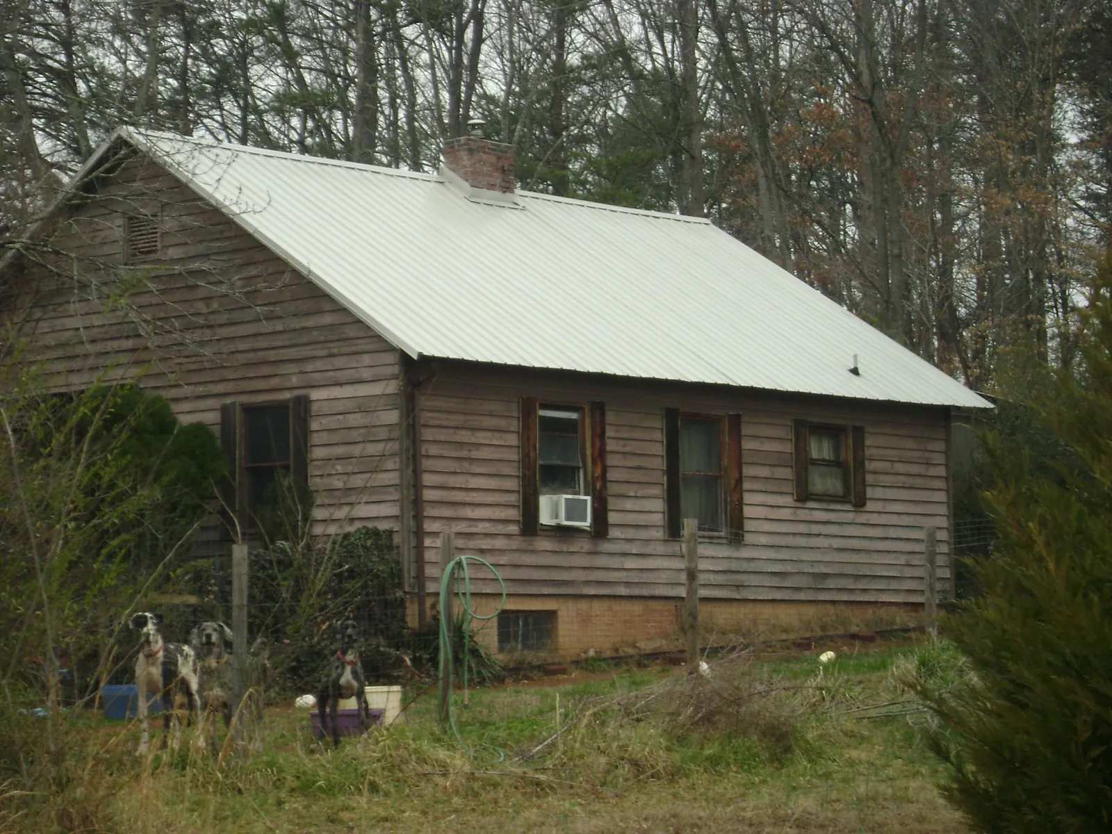 White metal roof on an old wood sided farmhouse, from a Asphalt Shingle Roof Repair job in Robins